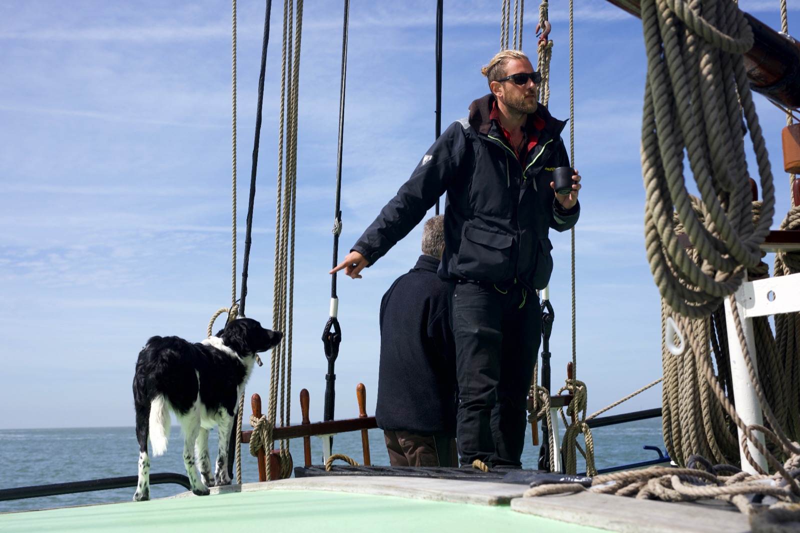 Fabio Andreatta navigating a traditional sailing ship with his sailing dog companion