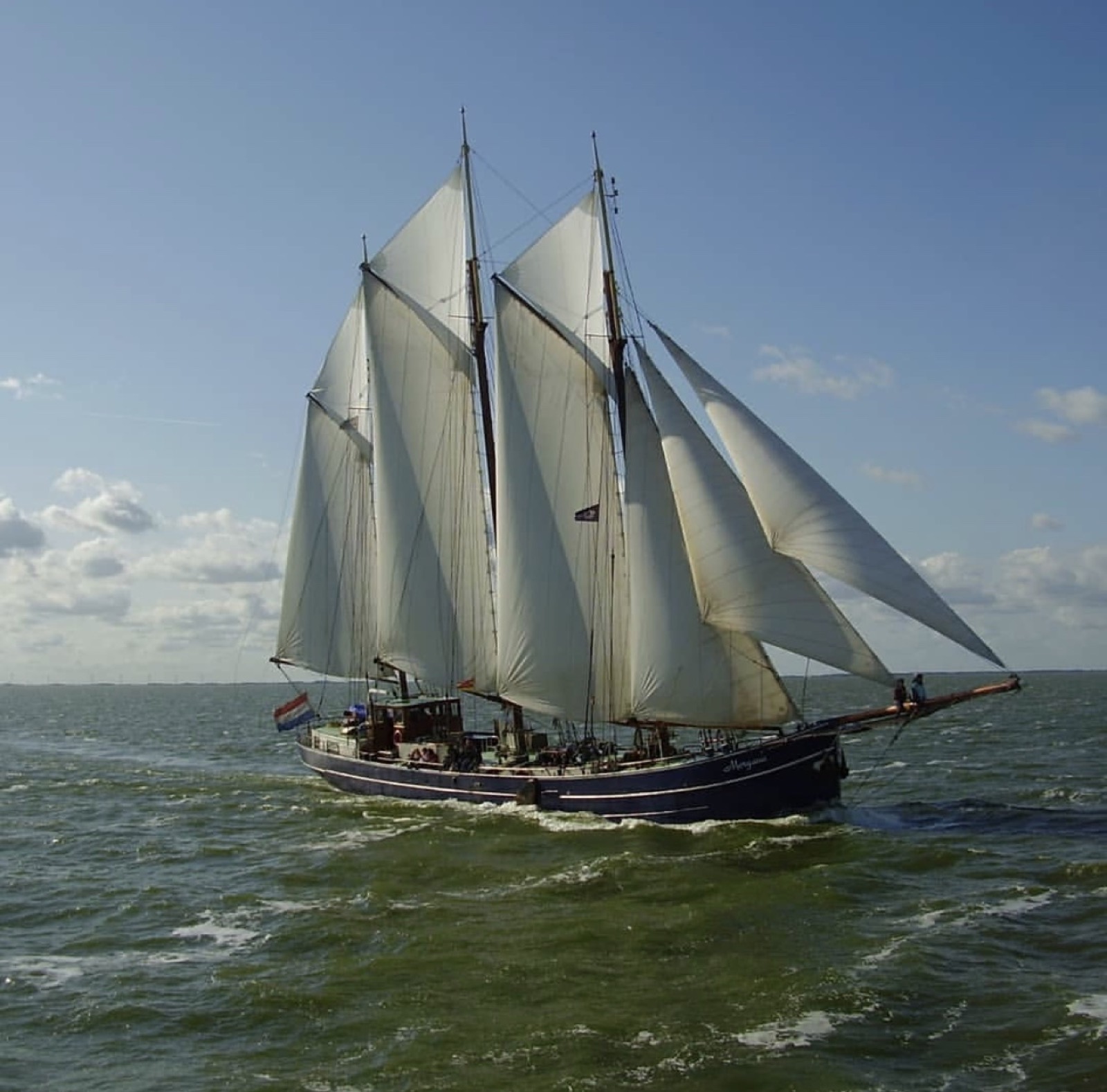 Traditional Dutch clipper under full sail on choppy seas